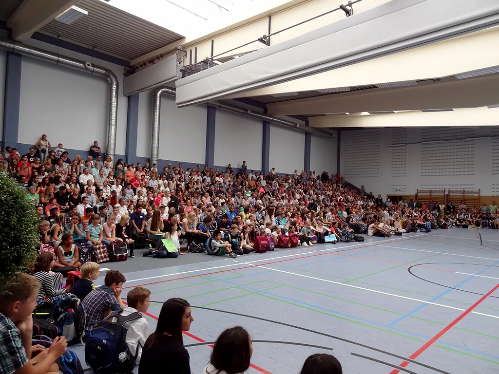 Weite Aufnahme der gefüllten Sporthalle.